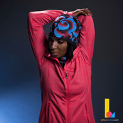 Woman stretching and wearing the Blue Flowers bamboo tuque for training and running. Paired with the Blue Flower tube anda pink running jacket