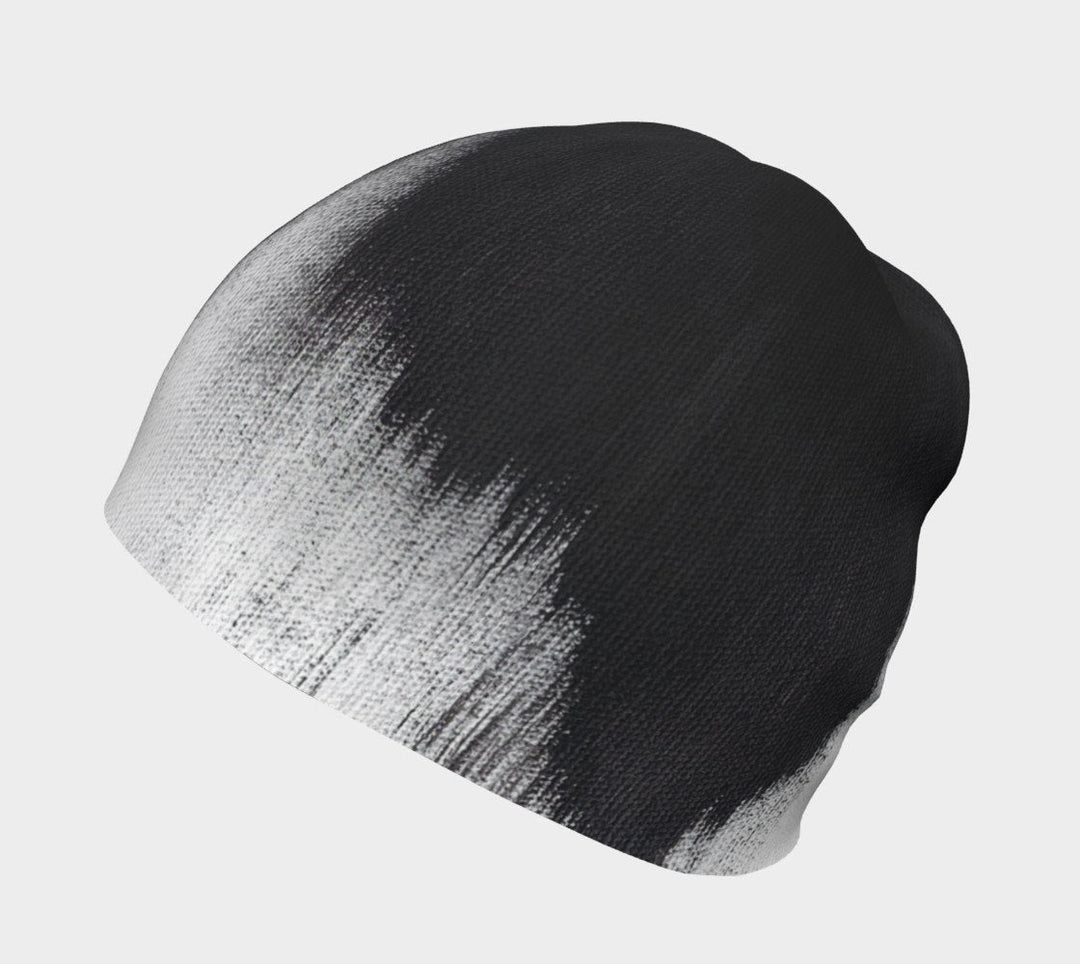Gros plan du motif abstrait noir et blanc de coups de pinceau sur une tuque grise.