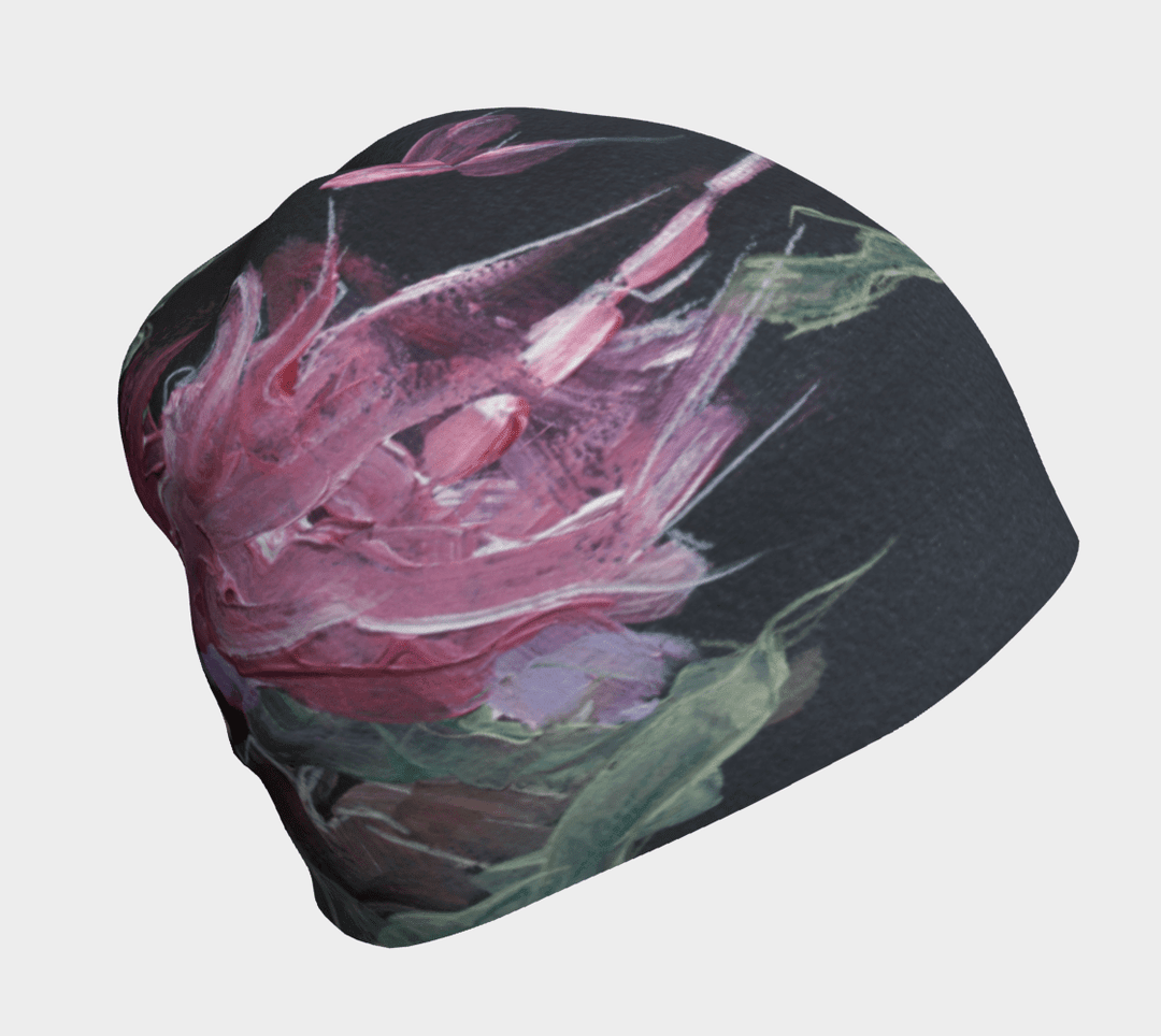 A black beanie with a vibrant pink and green floral art print shown from the front.