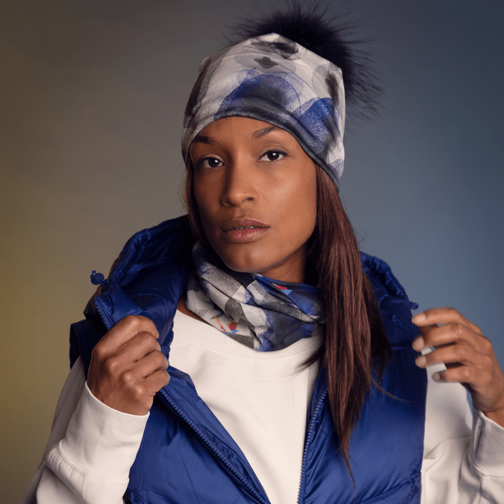 Femme portant la tuque et la tuque Plumes bleues, superposées à un veston d'hiver bleu.
