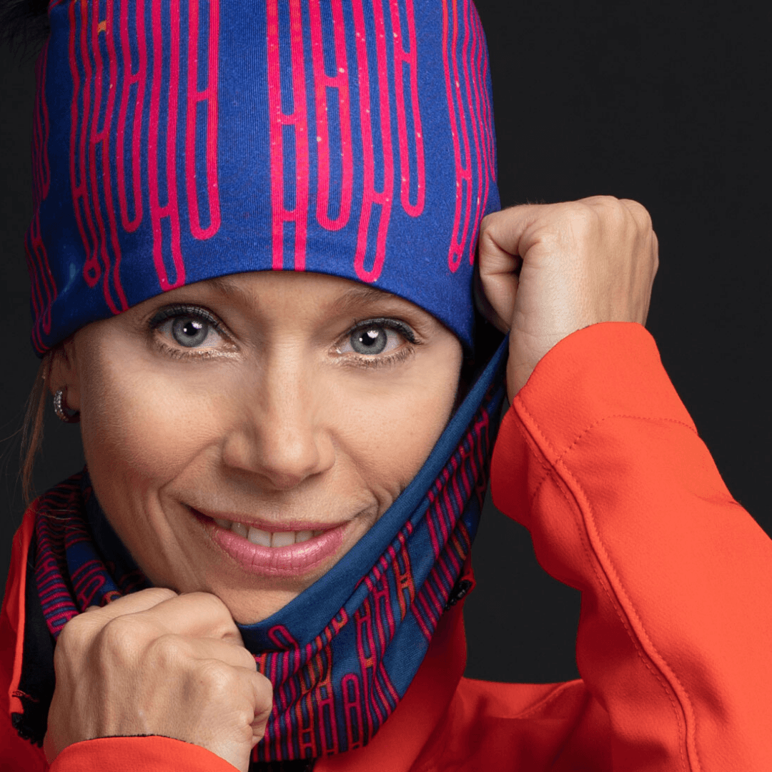 Une femme portant une tuque et un tube Blue Loops, tirant sur le tissu près de son visage.