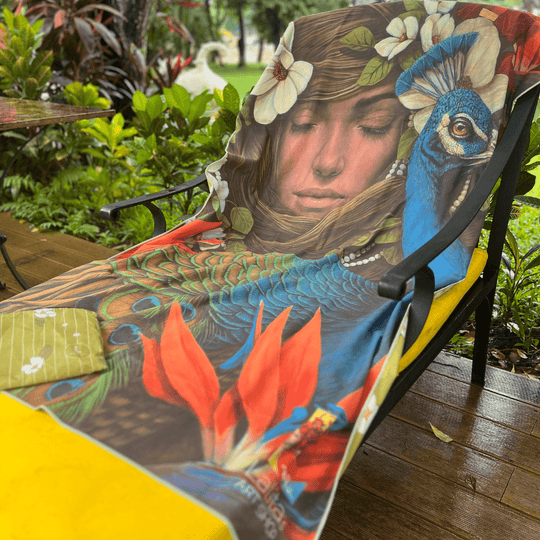 La serviette de plage artistique Chrysalide drapée sur une chaise d&