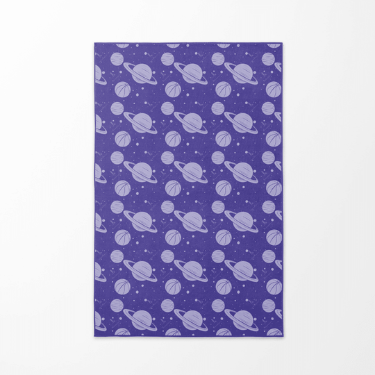 Face arrière de la serviette de plage "Cosmic Slam" avec un motif répétitif de planètes violettes et de ballons de basketball sur un fond étoilé.