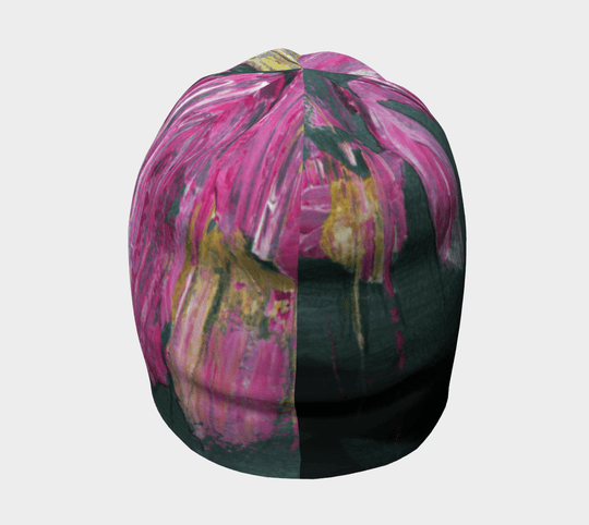 A beanie displaying a split view of the abstract floral art pattern, half dark green with pink accents, half pink with gold highlights.