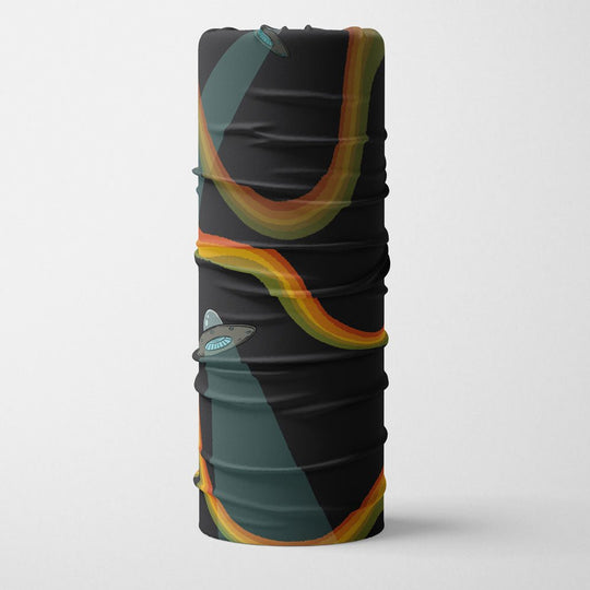 Cache-cou enroulé présentant un fond noir avec des soucoupes volantes et des rayons arc-en-ciel colorés.