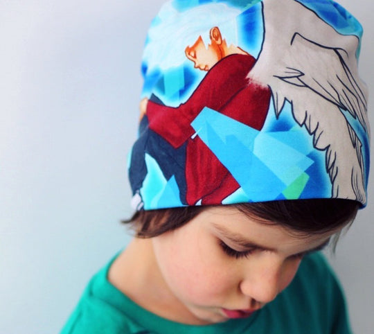 Jeune enfant portant la tuque Tête dans les Nuages, regardant vers le bas.