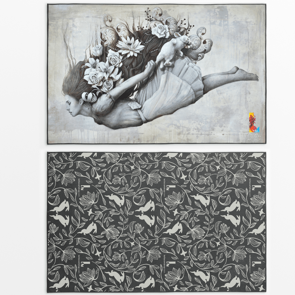 Reversible artistic towel showing the artwork of a woman with flowing hair and flowers, and a darker patterned side with rabbits and floral motifs.
