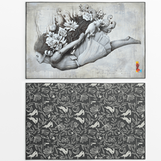 Reversible artistic towel showing the artwork of a woman with flowing hair and flowers, and a darker patterned side with rabbits and floral motifs.