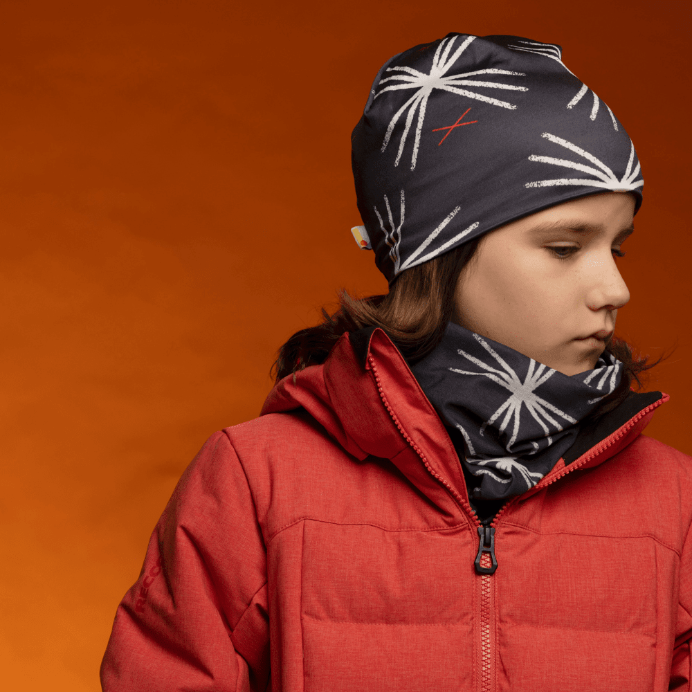 Une jeune personne portant la tuque MotifX Noire et un cache-cou assorti avec une veste d&