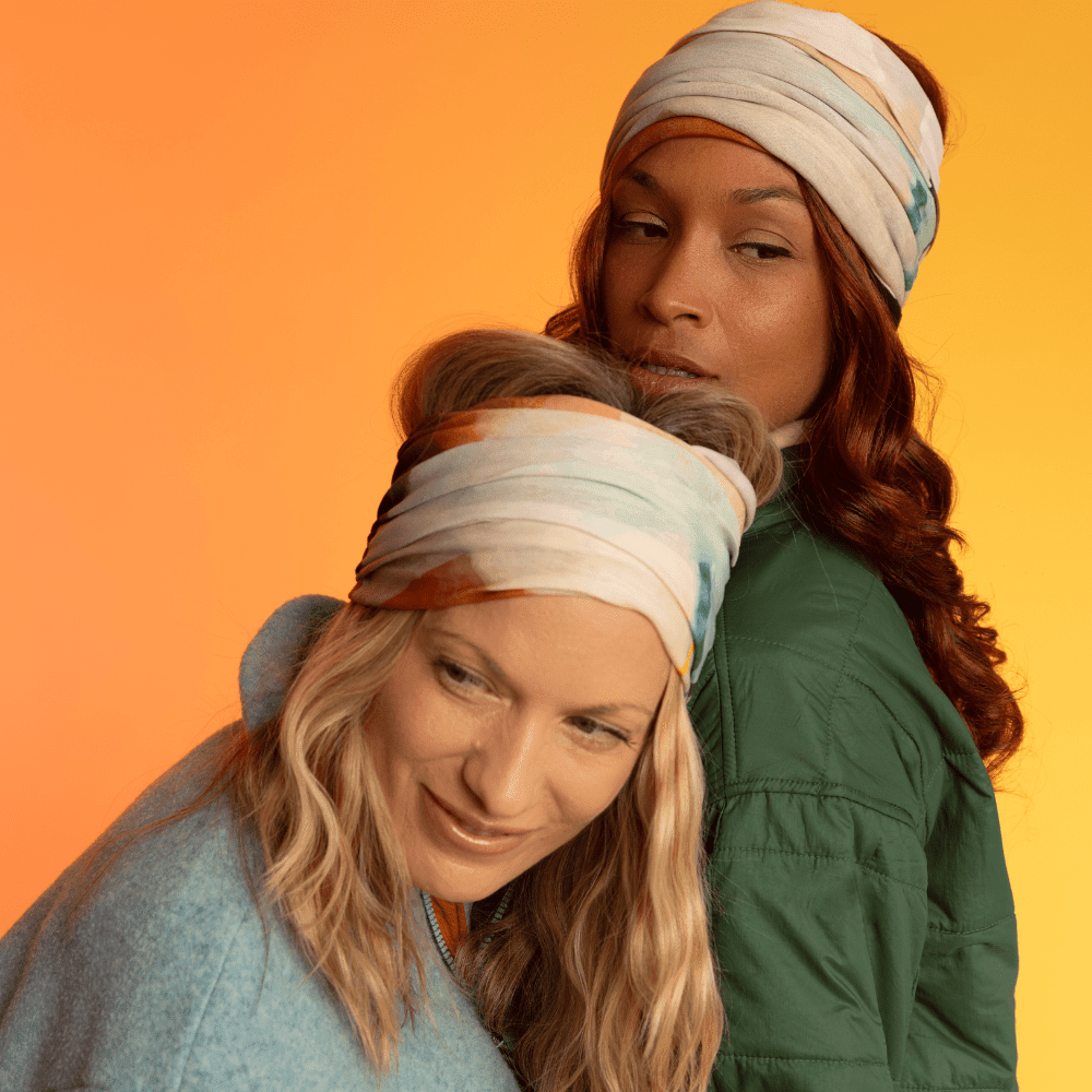 Two women, both wearing headbands made from the &