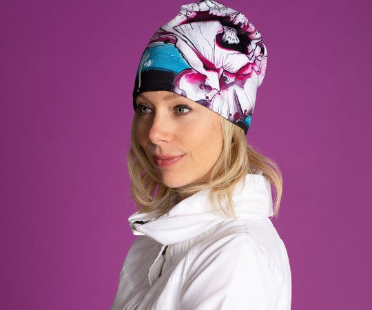 Femme portant la nouvelle tuque Fleur de pavot pour filles et femmes, mettant en valeur son design floral artistique sur fond violet.