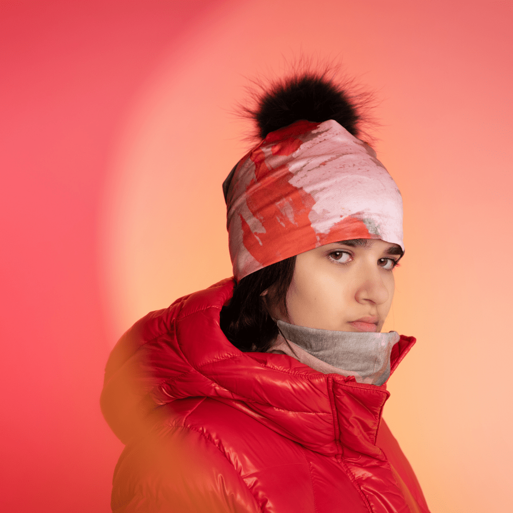 Mannequin portant la tuque Rose et Flammes avec un pompon noir et une veste rouge.