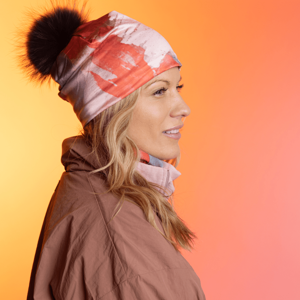 Femme portant la tuque Rose et Flammes avec un pompon noir, de profil.