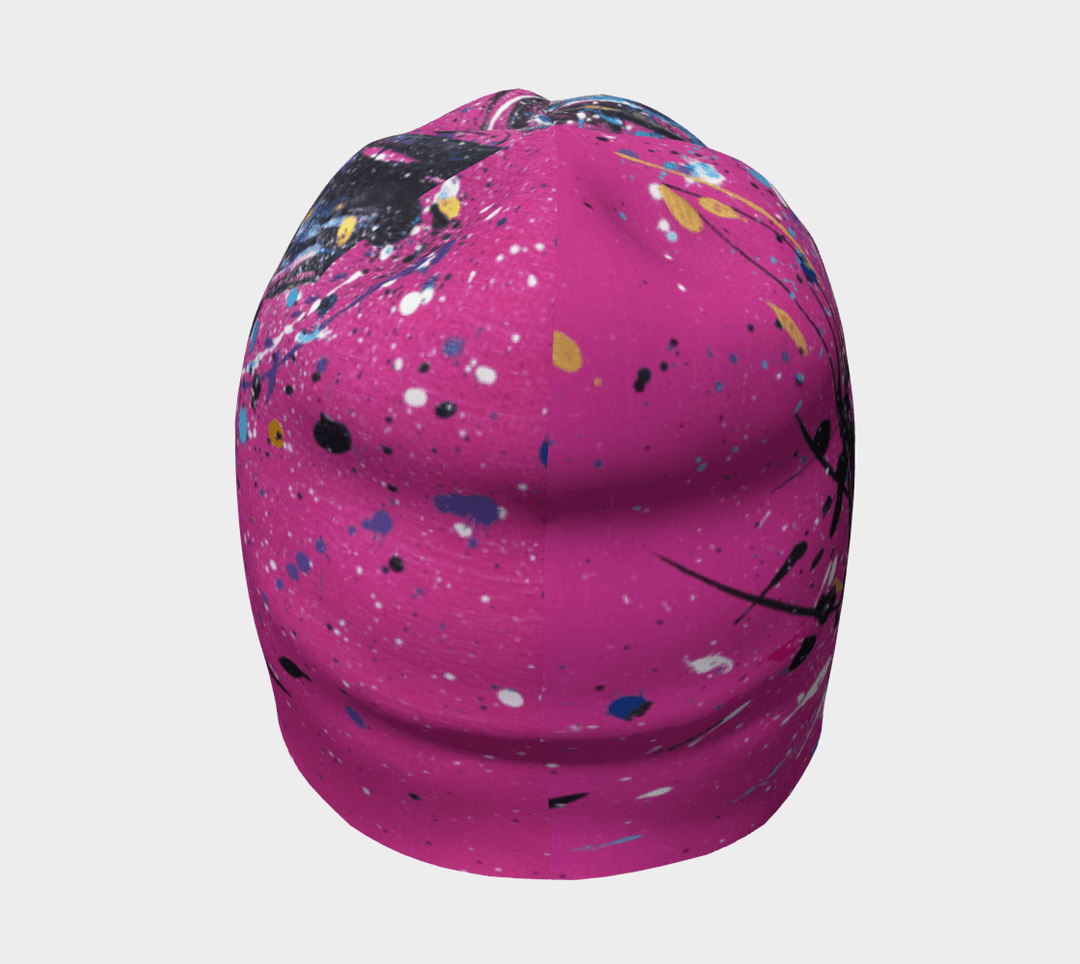 Une tuque rose avec un design abstrait de taches de peinture, vue de face.