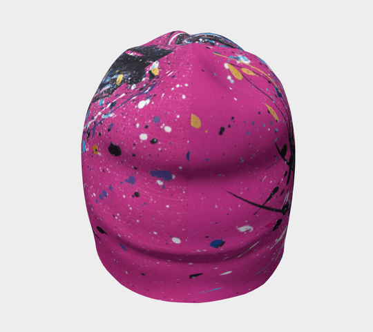 Une tuque rose avec un design abstrait de taches de peinture, vue de face.
