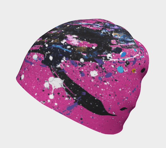 Une tuque rose avec un design abstrait de taches de peinture noires, bleues et blanches, sur fond blanc.