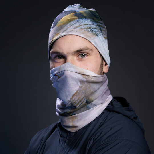 Homme portant une veste marine, avec le tissu à imprimé abstrait en masque facial et tuque.