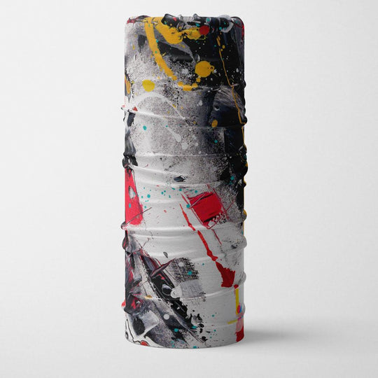 Un tube multifonction avec des éclaboussures de peinture abstraites rouges, blanches, jaunes et noires, roulé et debout.