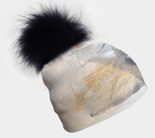 Tuque beige, blanc et noir à imprimé abstrait avec un gros pompon noir et moelleux