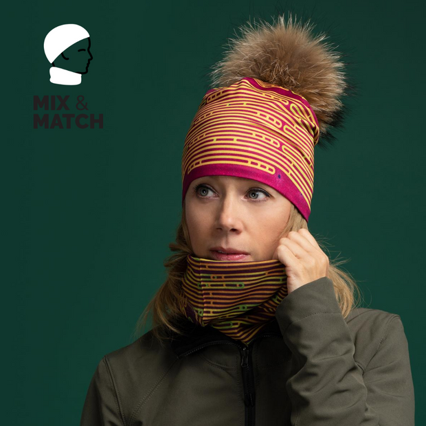 Woman wearing the sports Magenta beanie with removable pom  by Zaire with the multifunctional tube tat matches with it. 
