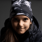 Young girl in front view wearing The unisex toque B&W with abstract pattern, and a detachable black pompom. This hat will match all your looks and activities. Finally, the perfect marriage between an original and trendy look with the tech features of sports toque!