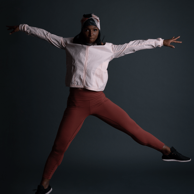 Woman doing a dance jump, wearing the La vie en rose beanie designed by artist Catherine Parent. This bamboo hat for women and girls is ideal for dance, yoga and outdoor activities. 