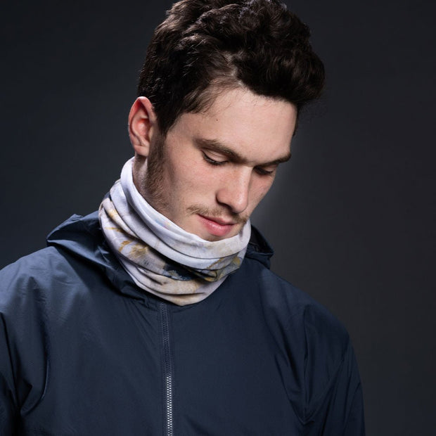 Young man wearing the Polar Sand Multi-use scarf with a fall dark gray jacket.
