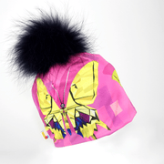 Left side view of the pink and purple butterflies beanie hat with navy fur pompom.