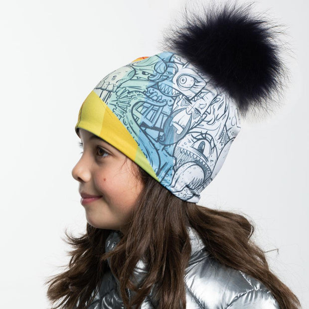 Side view of girl wearing Black and white doodle pattern toque with black pompon.