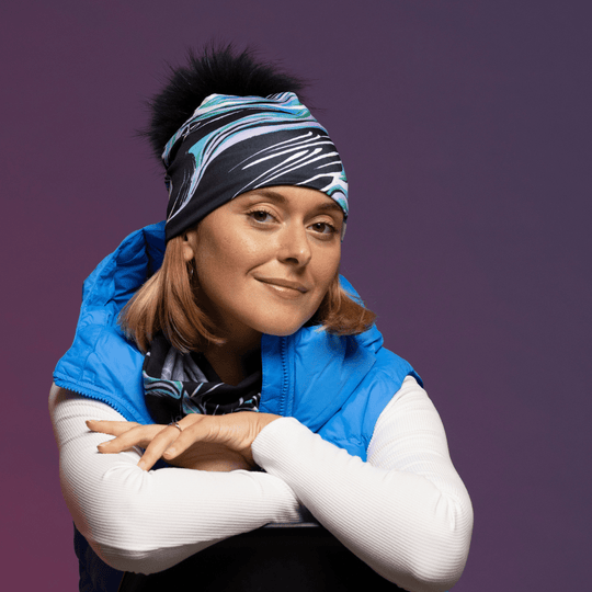 Woman smiling while wearing the new Heron Black and Blue beanie from Lalita&