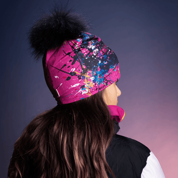 Girl showing a rear left view of the Nest BEanie Hat with Removable Pom paired with its multifunctional tube with fleece.