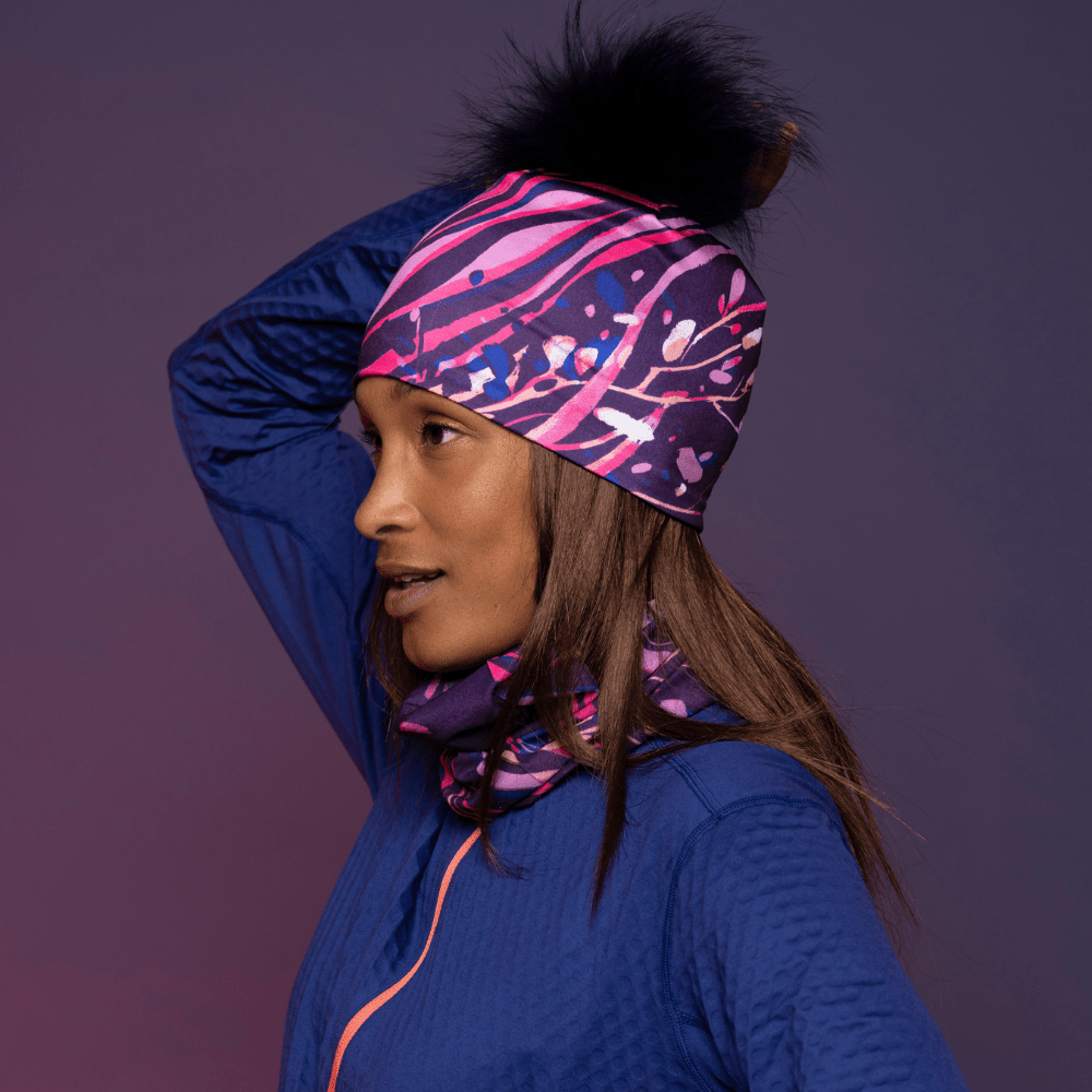Woman wearing the Magenta Owl Pompom beanie with assorted multifunctional tube for Lalita&