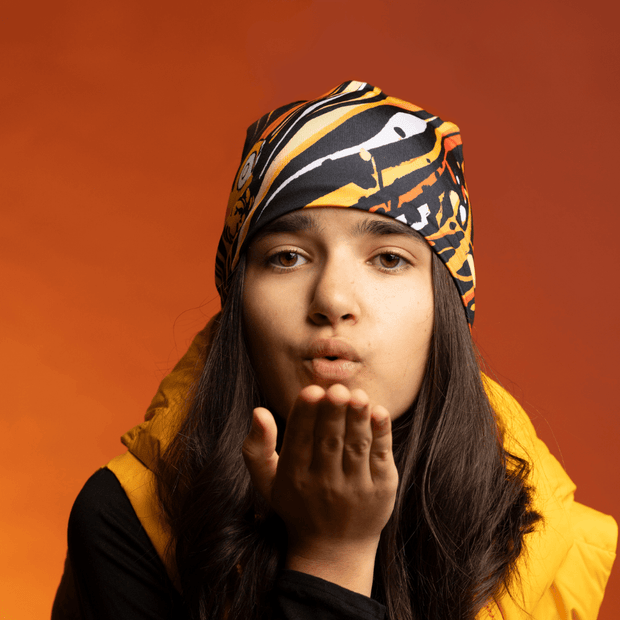 Young girl wearing the Orange and Black Owl Beanie by Julie Rocheleau for Lalita's Art Shop