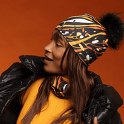 Woman facing left and wearing the Orange Owl beanie with Black pompom by Julie Rocheleau for Lalita's Art Shop
