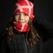 Teenage gril wearing the vibrant red beanie with peach lines. You can also see the  multifunction tube to match with it 