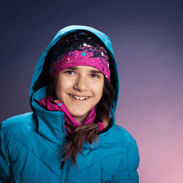 Teen Girl wearing the mix and match duo Nest toque and multipurpose scarf with fleece with a turquoise ski jacket. 