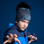 Young boy doing karate, wearing the Robocat 4seasons beanie designed by André Martel. The bamboo sports beanie hat has a black pompom