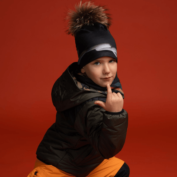 Boy wearing black Signature with natural fur pom. Best hats for kids and adults.