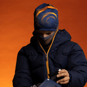 Boy wearing the Navy and Orange Sunrise Beanie with assorted tube by Zaire for Lalita's Art Shop