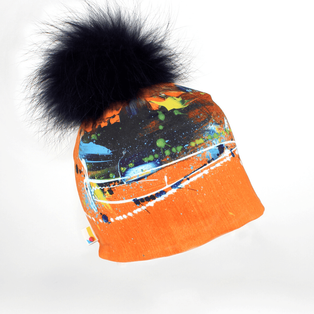 Right side view of the colourful orange beanie hat with navy blue pompom illustrated by Megane Fortin