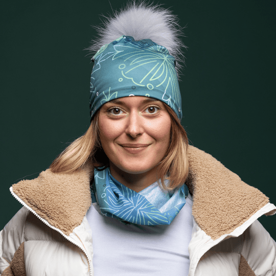 Young woman wearing the Blue Green multifunctional tube with assorted pompom beanie by Valery Goulet for Lalita&
